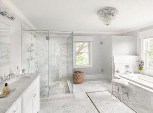 A bathroom featuring a pristine white marble floor and a stylish mirror reflecting the elegant surroundings